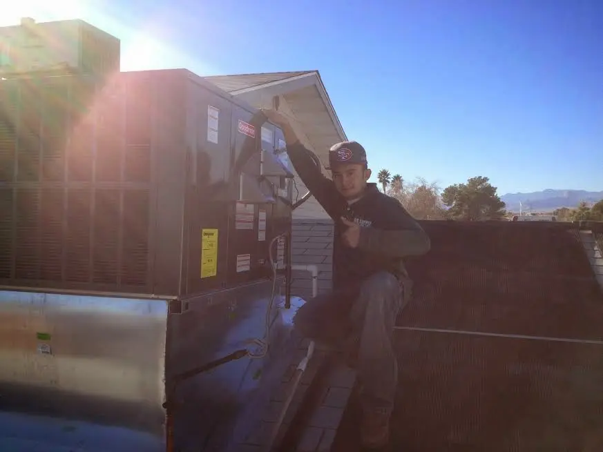 HVAC technician performing Heat Pump Repair on a rooftop unit in Roxborough Park